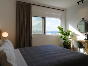 um quarto com uma cama, uma secretária e uma janela em Sea La Vie em Adelianos Kampos