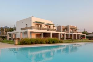 a house with a swimming pool in front of it at Kyma Suites - adult only accommodation in Almiros Beach