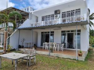 una casa bianca con un tavolo davanti di Vacation Beach House South of Mauritius - Riambel a Riambel