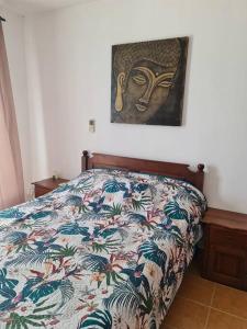 a bedroom with a bed with a painting on the wall at Vacation Beach House South of Mauritius - Riambel in Riambel
