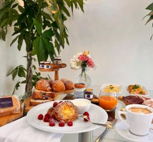 uma mesa com um prato de comida, café e pastelaria em Experience Boutique Hotel - Villa Cimmino em Castellammare di Stabia