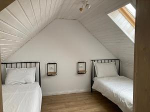 Duas camas num quarto com um sótão em Cabana Maia em Fundstica