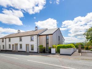 una casa blanca con techo negro en 5 Clough Cottages en Clitheroe