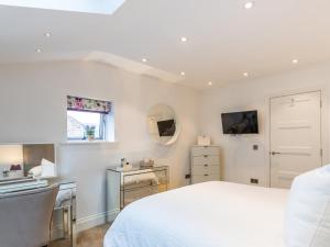 a bedroom with a bed and a desk and a mirror at 5 Clough Cottages in Clitheroe