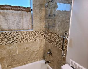 uma casa de banho com um chuveiro, uma banheira e um lavatório. em Stylish Suite Tampa Minutes to Hard Rock Casino em Tampa