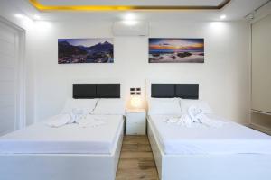 2 camas en una habitación con paredes blancas en Addie's Place Soldiers Hills Village Muntinlupa, en Manila