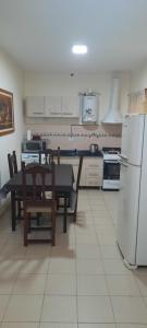 a kitchen with a table and a refrigerator at Casa-prefabricada in Villa María