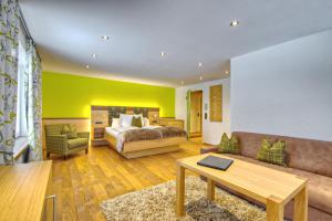 uma sala de estar com uma cama e um sofá em DIANA Naturpark Hotel - mit Oberstaufen Plus Golf em Oberstaufen