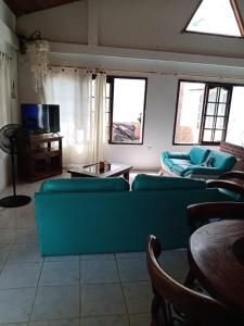 sala de estar con sofá azul y TV en Villas de León en Leticia