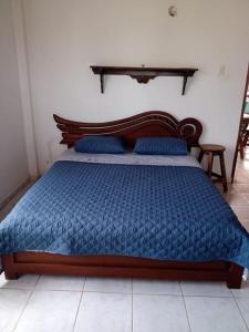 a bed with a blue comforter and blue pillows at Villas de León in Leticia
