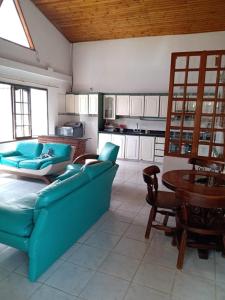 ein Wohnzimmer mit einem blauen Sofa und einem Tisch in der Unterkunft Villas de León in Leticia