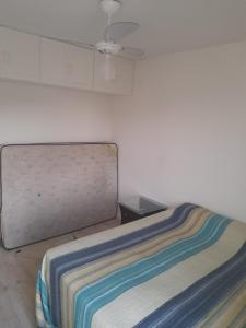 Cama en habitación con pared blanca en Apartamento para Carnaval, en Salvador