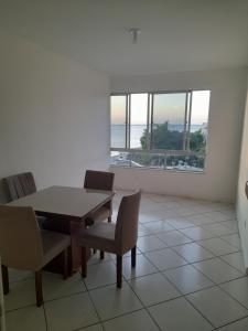 comedor con mesa y sillas y ventana grande en Apartamento para Carnaval, en Salvador