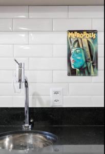 een wastafel in de badkamer met een bord op de muur bij Studio vista para cidade in Sao Paulo
