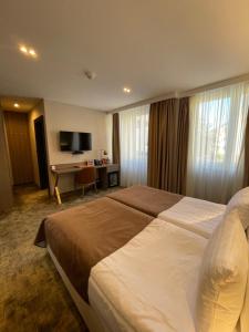 PribojにあるHotel Terme 36.6の大きなベッドとデスクが備わるホテルルームです。
