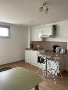 a kitchen with white cabinets and a table in it at Les Sept Logias in Les Loges