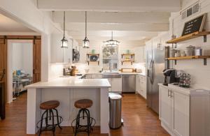 eine Küche mit einer Theke und 2 Hockern in der Unterkunft Sea Side Cottage - 4217 Second Street in East End