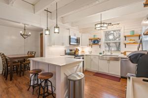 eine Küche mit weißen Schränken und einem Tisch und Stühlen in der Unterkunft Sea Side Cottage - 4217 Second Street in East End + 6 Fotos