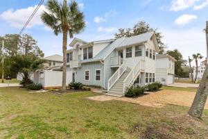 ein Haus mit einer Palme davor in der Unterkunft Sea Side Cottage - 4217 Second Street in East End
