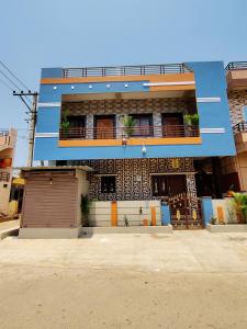un edificio azul con un garaje delante en Balaji Homestay en Hampi