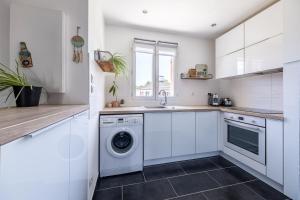 a white kitchen with a washer and dryer at Confort Golf Disney in Bailly-Romainvilliers