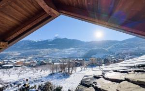 una vista da una finestra di una città nella neve di Hérisson ad Aosta