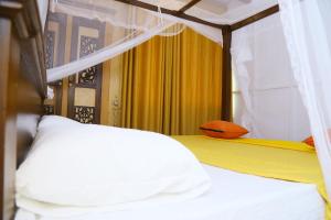a bedroom with two beds and a yellow curtain at YOUTHENI VILLA in Weligama