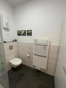 La salle de bains est pourvue de toilettes blanches. dans l'établissement Heimathafen Wanne, à Herne