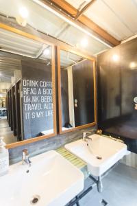 two sinks in a bathroom with a mirror at The Yard Bangkok Hostel in Bangkok +85 photos