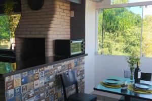 a kitchen with a table and a brick fireplace at Apartamento Por do Sol - Cobertura in São Roque +33 photos