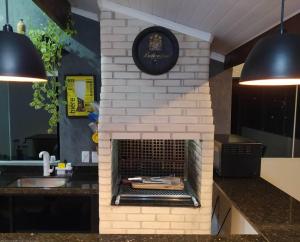 a kitchen with a brick fireplace in a kitchen at Apartamento Por do Sol - Cobertura in São Roque