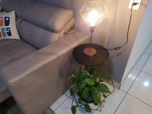 a lamp on a side table next to a couch at Apartamento Por do Sol - Cobertura in São Roque