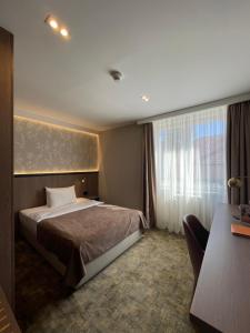 Hotel Terme 36.6 في Priboj: غرفه فندقيه بسرير ونافذه