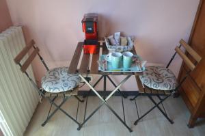 two chairs and a table with two mugs on it at B&B Del Tempo Stretto in Albenga