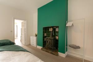 1 dormitorio con pared verde y chimenea en Near hospital, Netflix, Sleeps up to 3, Fast Wi-FI en Lincoln