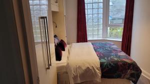 ein kleines Schlafzimmer mit einem Bett und einem Fenster in der Unterkunft Rathlin Apartments, Apt4 2 ramore avenue portrush BT56 8BB in Portrush