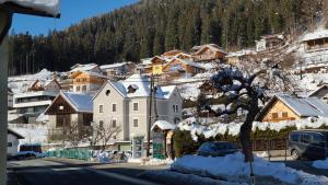 a snow covered town with houses and a mountain at Rooms 4 Holiday in Kirchbach
