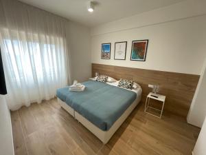 a bedroom with a bed with blue sheets and a window at Colombo 1935 - Apartments in Follonica