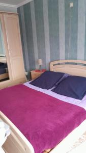 una camera da letto con un letto grande con una coperta viola di B & B Vandenbroucke Joseline a Ypres