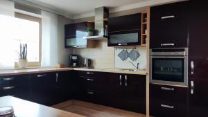 a kitchen with black cabinets and a sink at Ferienwohnung Schottenheim in Nabburg