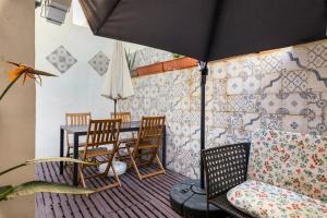 a patio with a table and chairs and an umbrella at 1 Bedroom Apartment with cosy Backyard close to Valletta in Il-Furjana