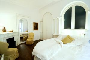 um quarto branco com uma cama e uma lareira em Secret Garden Villa Borghese em Roma