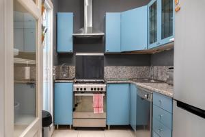 a kitchen with blue cabinets and a stove at 1 Bedroom Apartment with cosy Backyard close to Valletta in Il-Furjana +13 photos
