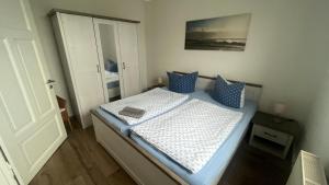ロストックにあるFerienwohnung mit Warnowblickの小さなベッドルーム(青い枕のベッド付)