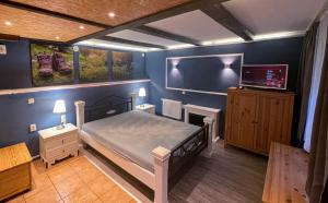 Schlafzimmer mit einem Bett und einem Flachbild-TV in der Unterkunft Ferienhaus-Elisabeth Bungalow-Tom Bungalow-Peter in Reinhardtsdorf