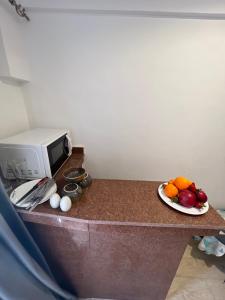 a plate of fruit on a counter next to a microwave at PYRAMIDS TOP IN in Cairo