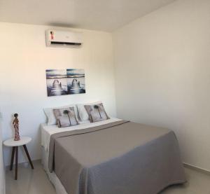 Dormitorio blanco con cama y mesa en Casa na Praia Maragogi 2.0, en Maragogi