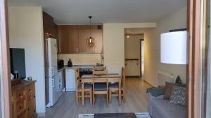a kitchen and living room with a table and a dining room at Apartament Ca La Nena in Esterri d'Àneu