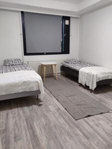 トルニオにあるStyle 1BR with sauna,Tornio cityのベッド2台とプロジェクションスクリーンが備わる客室です。