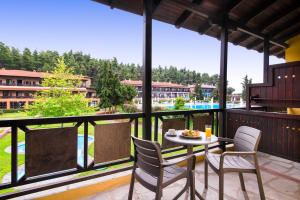 um pátio com uma mesa e cadeiras numa varanda em Simantro Resort em Sani Beach